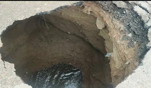 Road collapse on Basai road after heavy night rain in Gurugram creates deep pit
