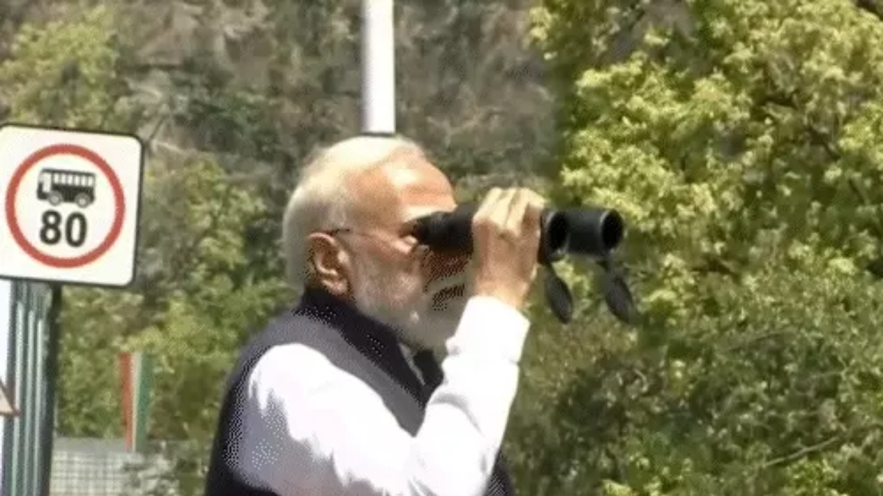 PM Modi viewing the wildlife corridor through binoculars.